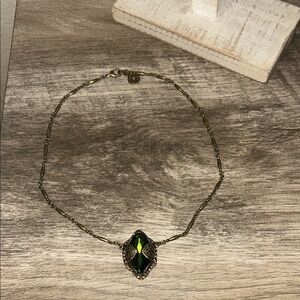 Elegant Gold Necklace with Black and Green Gem